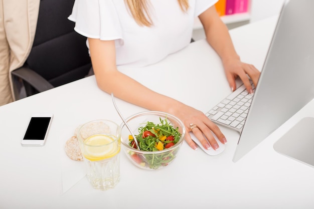 Mulher no escritório com almoço saudável