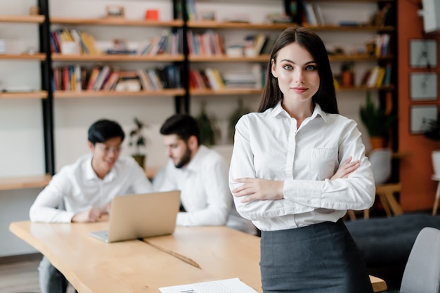 Mulher no escritório trabalha com equipe de colegas de trabalho na mesa