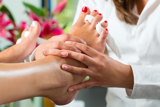 Mulher no estúdio de unhas recebendo pedicure