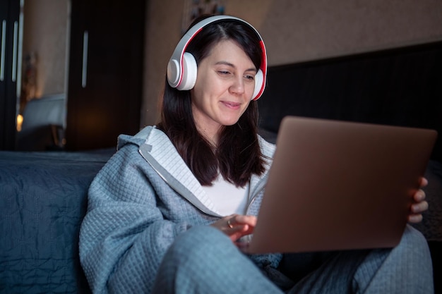 Mulher no fone de ouvido trabalhando no laptop tem chamada de vídeo