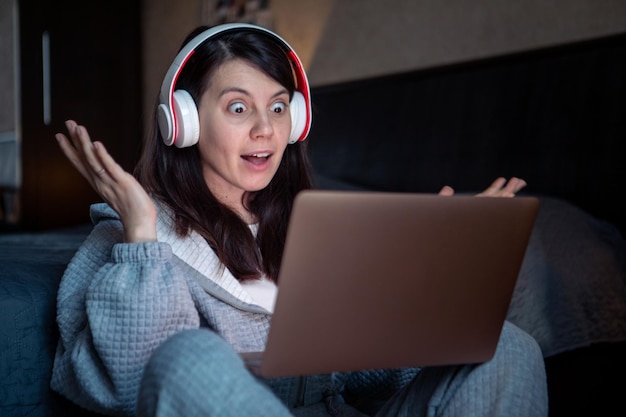 Mulher no fone de ouvido trabalhando no laptop tem chamada de vídeo