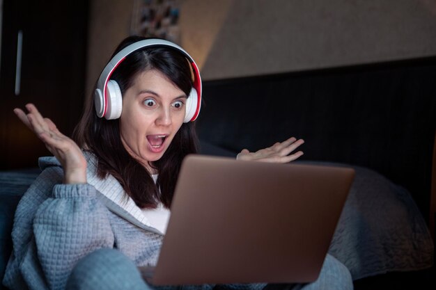 Mulher no fone de ouvido trabalhando no laptop tem trabalho remoto de videochamada em casa