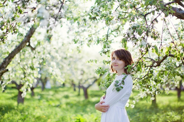 Mulher no jardim de primavera de vestido branco