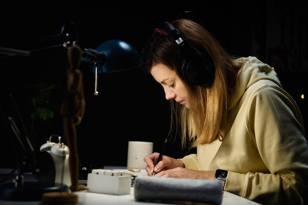 Mulher no local de trabalho em casa usando laptop à noite