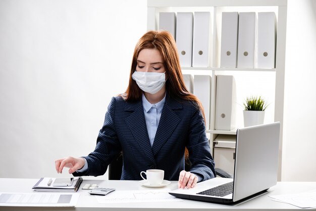 Mulher no local de trabalho na máscara médica