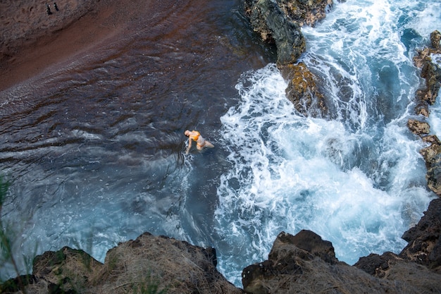 Mulher no mar perto das ondas, vista de cima, fotos aéreas