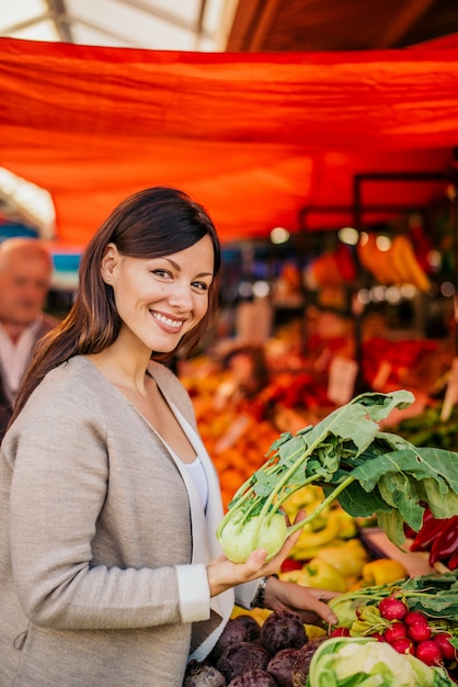 Foto mulher no mercado, comprando comida.