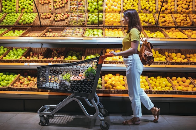 Mulher no mercado de mercearia com carrinho de compras