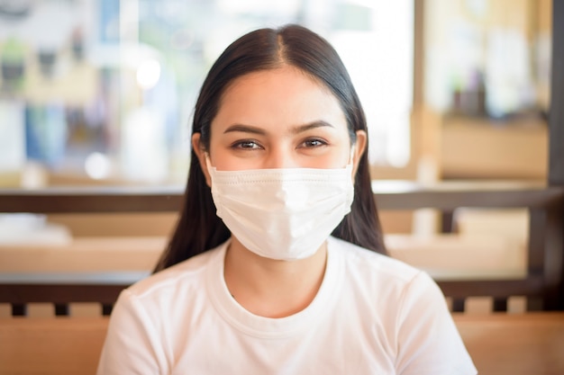 Mulher no restaurante com máscara facial de proteção