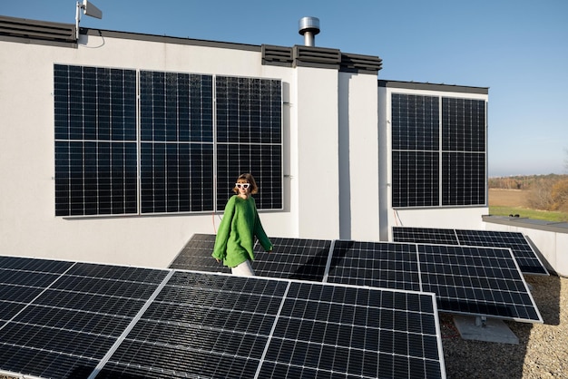 Mulher no telhado de sua casa com uma estação solar