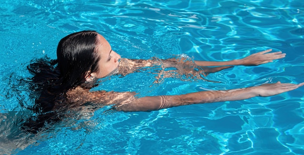 Mulher nua ao ar livre. Mulher jovem e bonita nua na piscina.