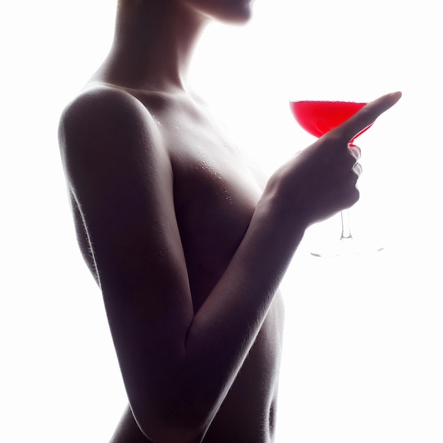 Mulher nua de corpo molhado com vinho tinto