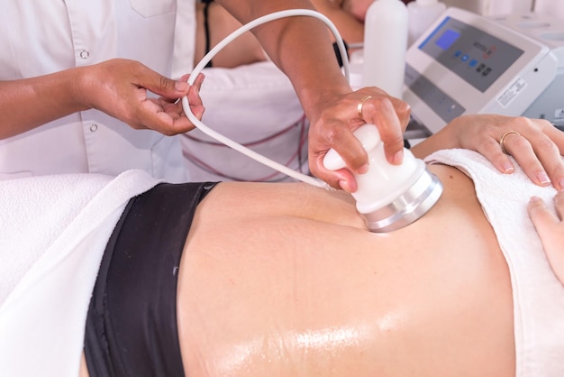 mulher num centro de beleza a remover celulite do abdômen