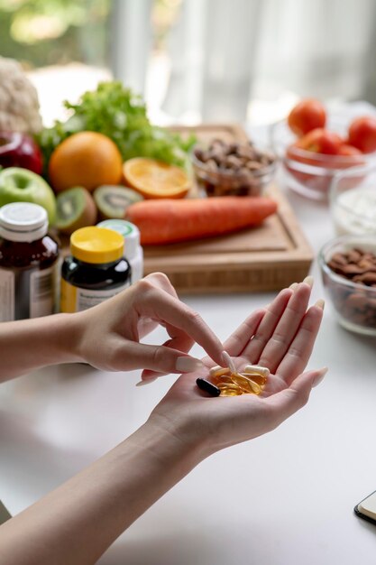 Mulher nutricionista profissional verificando suplementos dietéticos na mão, cercada por uma variedade de frutas, nozes, vegetais e suplementos dietéticos na mesa