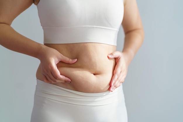 Mulher obesa barriga de gordura corporal mão segurando o conceito de estilo de vida dieta de gordura da barriga excessiva para reduzir a barriga e moldar o músculo do estômago saudável