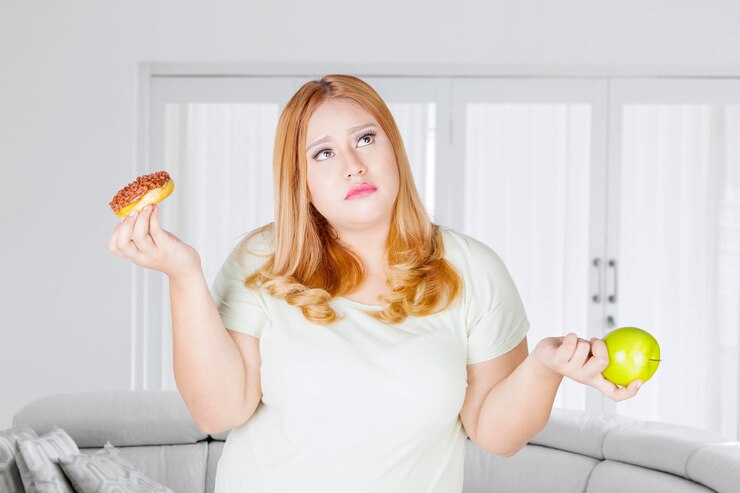 Foto mulher obesa confusa com rosquinhas e frutas de maçã