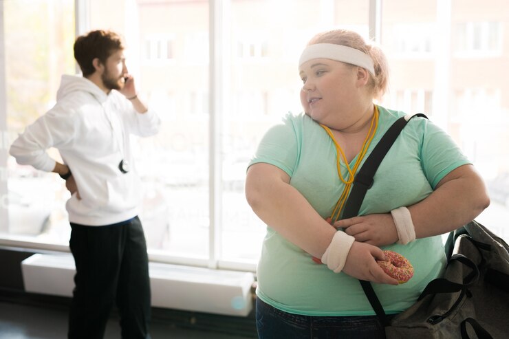 Foto mulher obesa escondendo comida de seu treinador