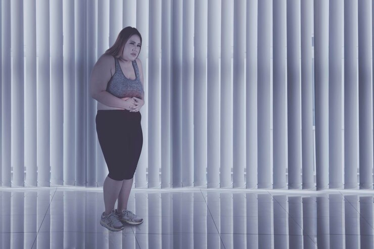 Foto mulher obesa sofre de dores abdominais em casa