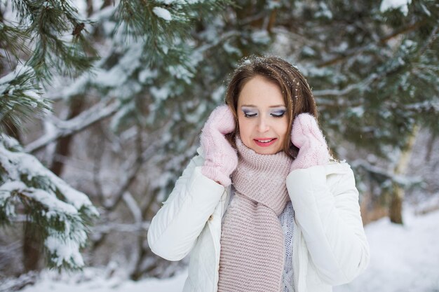 Mulher olha para baixo e milhas sob a árvore coberta de neve