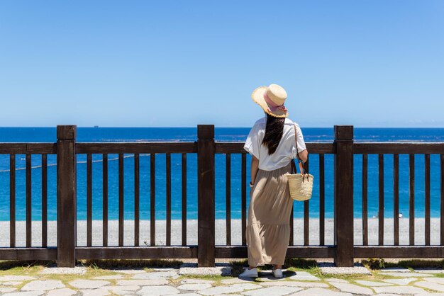 Mulher olha para o mar no verão