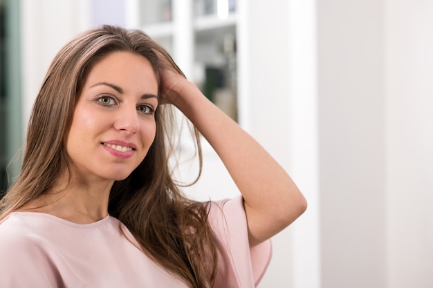 Mulher olhando para a câmera e tocar no cabelo