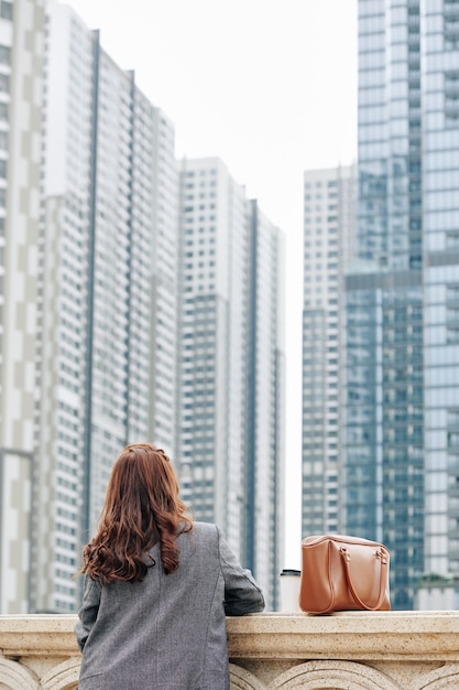 Mulher olhando para edifícios altos