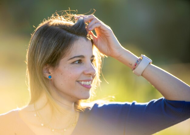 Foto mulher olhando para longe e sorrindo enquanto desfruta do dia ao ar livre na natureza durante o pôr do sol