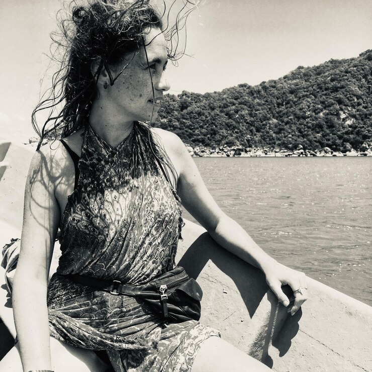 Foto mulher olhando para longe enquanto está sentada em um barco