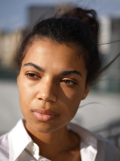 Foto mulher olhando para longe enquanto posava ao ar livre em um dia ensolarado. foco seletivo