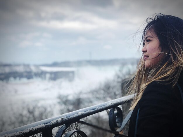 Foto mulher olhando para o céu durante o inverno