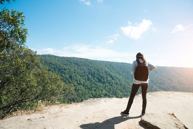 Mulher olhando para o céu em vista da montanha para a luz do sol