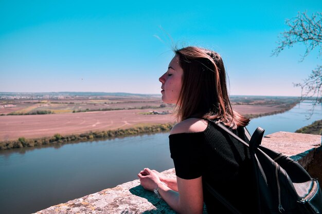 Foto mulher olhando para o mar contra o céu