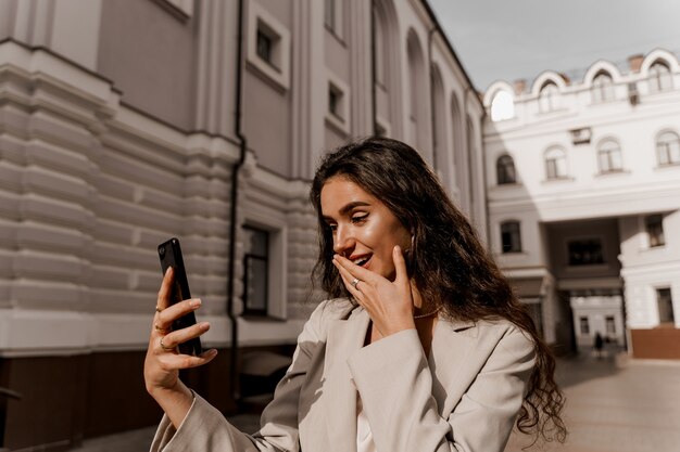 Mulher olhando para smartphone em estado de choque