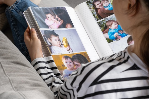 Mulher olhando para um álbum de fotos de família sobre sua família