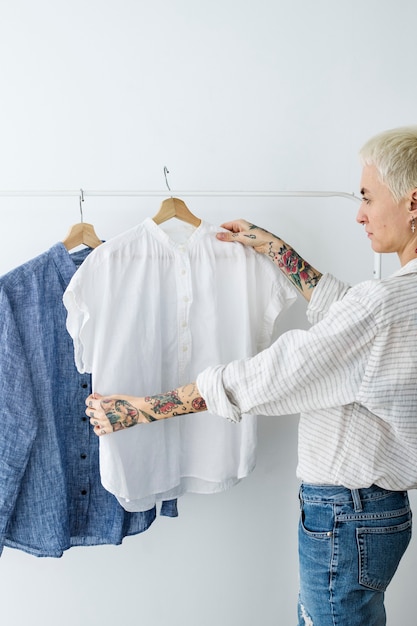 Mulher olhando para uma camisa branca