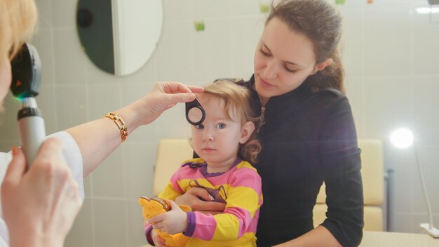 Foto mulher, optometrista na clínica verifica a visão na oftalmologia de uma menina