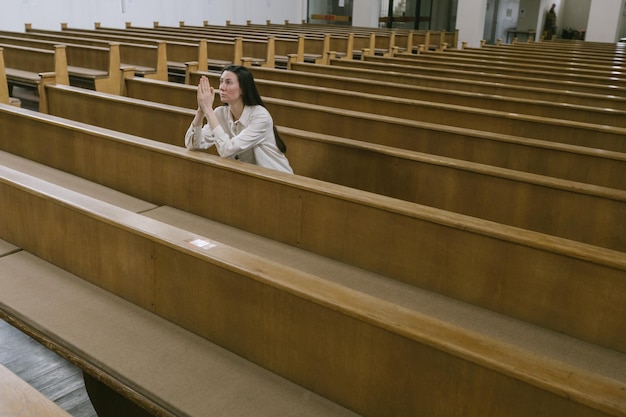 Mulher orando a Deus na igreja