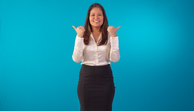 Mulher oriental adulta com roupa formal em foto de estúdio com fundo azul.