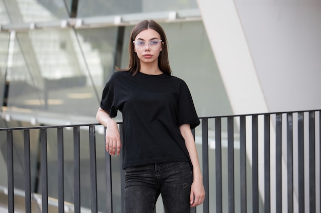 Mulher ou menina vestindo uma camiseta preta de algodão em branco com espaço para seu logotipo, mock up ou design em estilo urbano casual