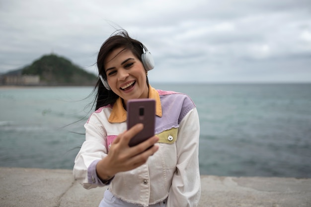 Mulher ouvindo música com smartphone na rua