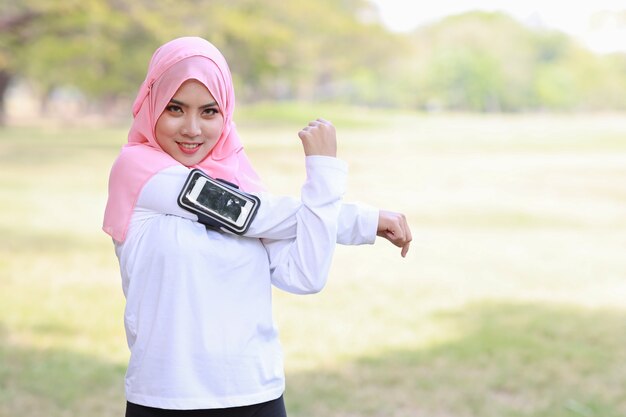 Mulher ouvindo música em fones de ouvido sem fio e celular enquanto se exercita ao ar livre