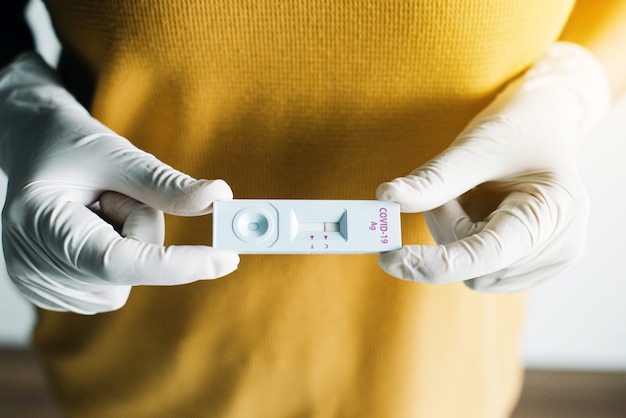 Foto mulher paciente mostrando resultado de um kit de teste rápido de antígeno de autoteste covid-19 em casa