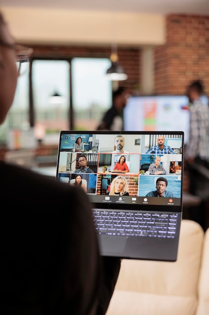 Foto mulher participando de videochamada de reunião de negócios com colegas, falando em videoconferência online com webcam. usando laptop para falar em chat de teleconferência remota, telecomunicações.