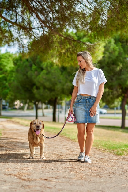 Mulher passeando com o cachorro no parque.