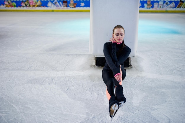 Mulher patinadora artística na pista de patinação no gelo