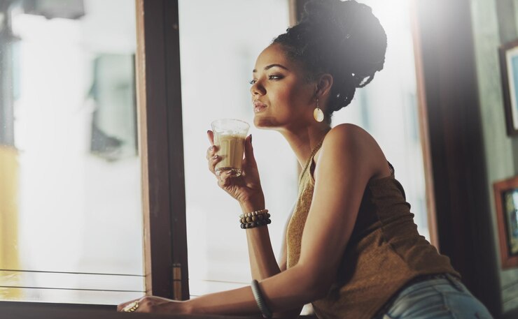 Foto mulher pensativa e relaxar no café com café bebida quente e séria com confiança pela janela pessoa feminina pensando e bebendo no restaurante para almoço chá e expresso com cafeína