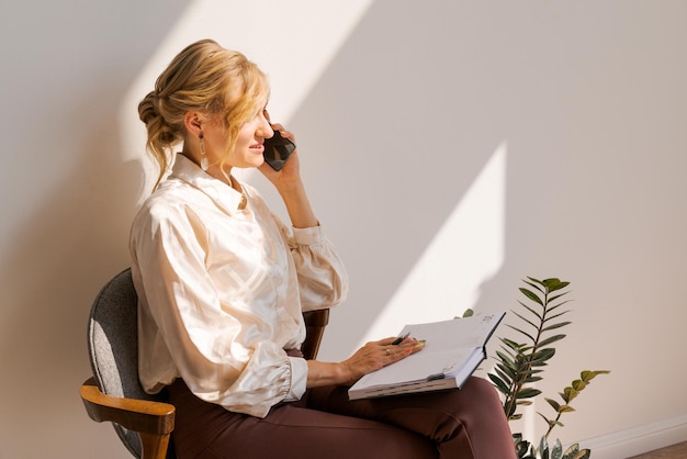 Mulher pensativa no escritório planejando horário de trabalho no notebook sentado