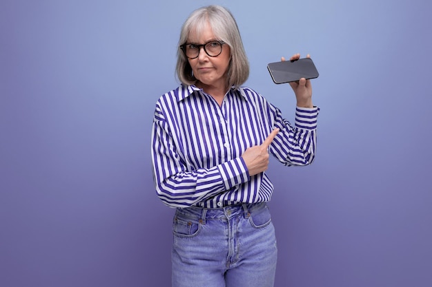 Mulher pensionista moderna com cabelos grisalhos dominando a nova técnica de smartphone com maquete em brilhante