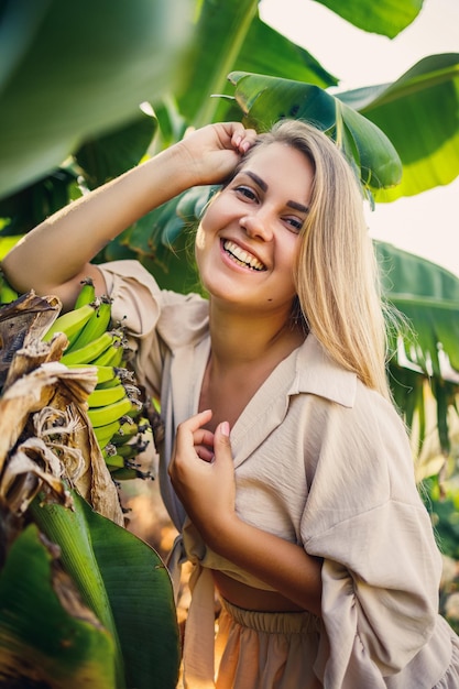 Mulher perto de grande folha verde de bananeira na natureza no parque Plantas tropicais