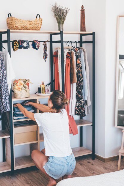 Foto mulher perto de seu armário de casa aberta espaço organizador conceito de organização de armazenamento